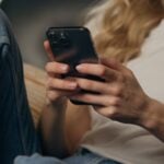 Close,Up,Smiling,Woman,Client,Browsing,Mobile,Phone,At,Home Let Us Know How We Did
